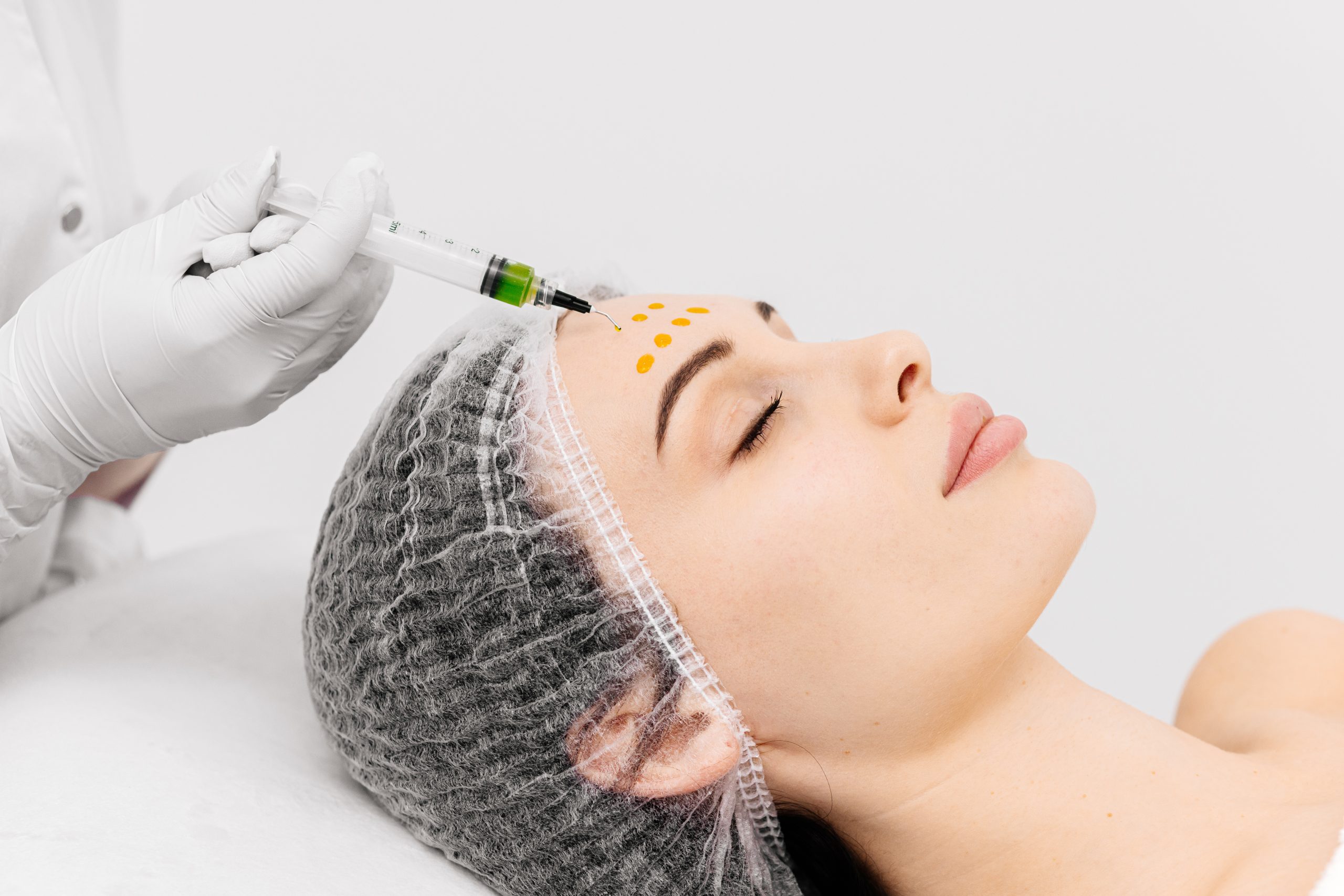 Close-up of a cosmetologist performing a facial peel on a young woman. Concept of professional care, rejuvenation, and healthy skin.
