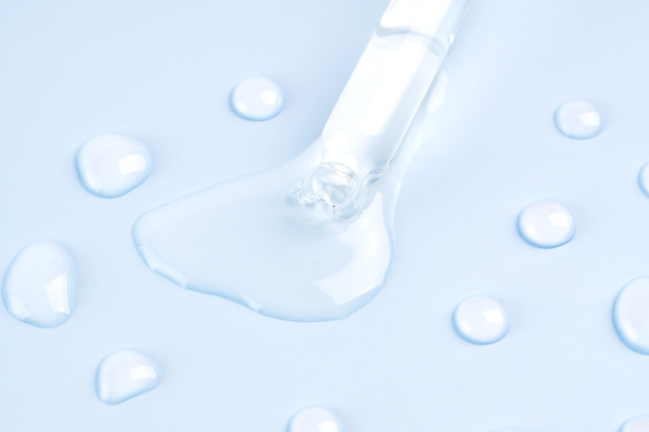 Bottle pipette dropper close up and Liquid hyaluronic serum on a blue background Bottle pipette dropper close up and Liquid hyaluronic serum on a blue background